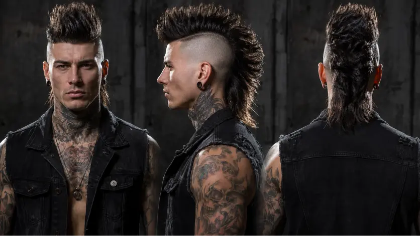 Man with a modern mullet fade haircut featuring textured volume on top, faded sides, and longer layered hair at the back for a bold stylish look